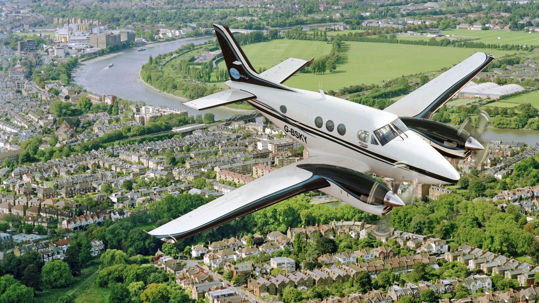 Photograph of a survey plane flying over a residential area
